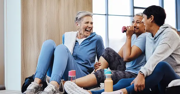 A group of ladies laughing during a fitness class.